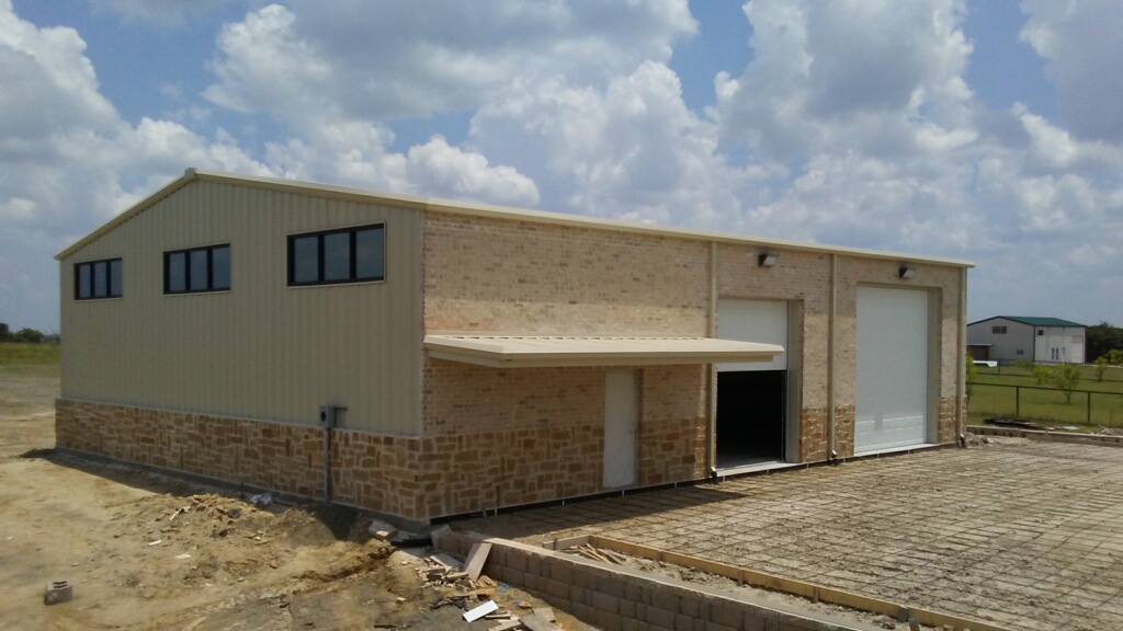 Residential shop with stone exterior and overhead doors in Heath, Texas